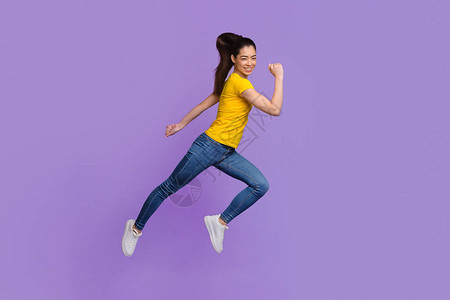 在快乐的亚洲女孩在空中跳跃穿越紫色背景的动画中图片