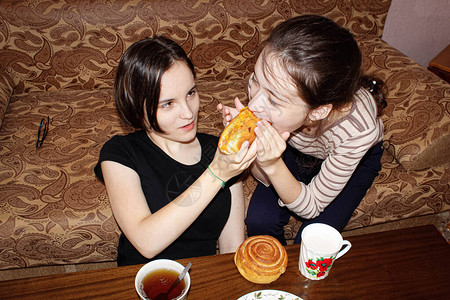 家里两个姐妹在沙发上喝着茶图片