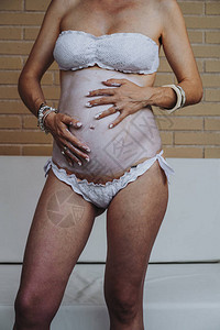 孕妇在腹部涂抹奶油的特写图片