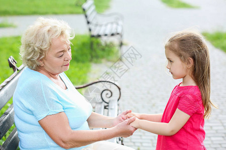 可爱的小女孩祖母在户外手牵图片