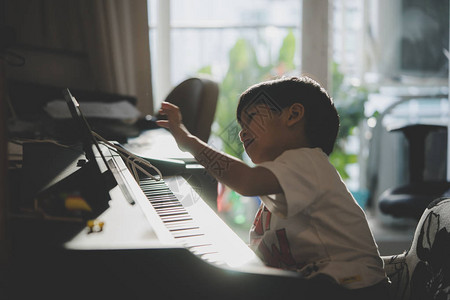 小男孩在家玩钢琴和音乐片图片