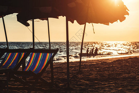 沙滩椅下的沙滩和日落图片