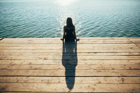 孤单的女孩坐在码头上图片