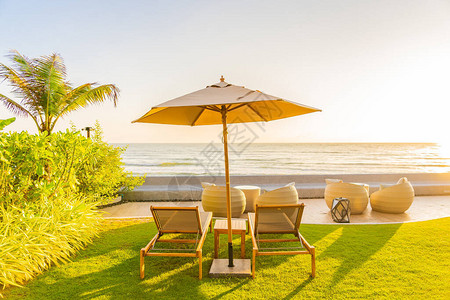 日落或日出时在海边滨周围的保护伞和椅子图片