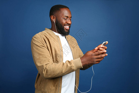 非洲裔美国快乐男子在彩色背景上听音乐也图片