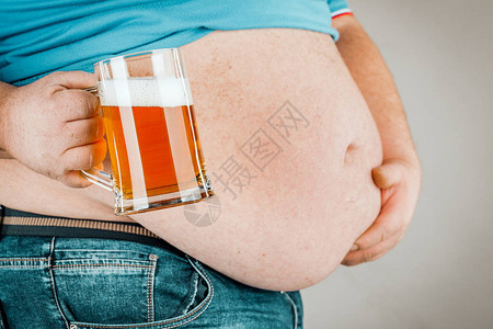 一个长着胖肚子的人拿着啤酒图片