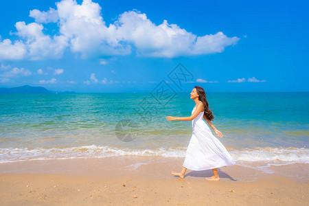 肖像美丽的亚洲年轻女子在沙滩海和洋上快乐微笑休闲图片