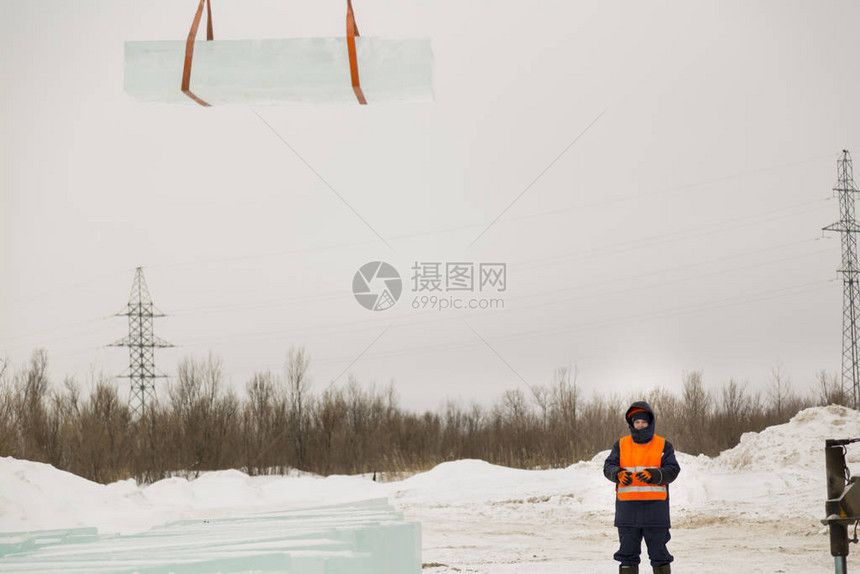 橙色反射背心和头盔的工人吊车图片