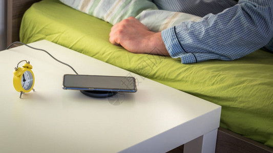床边桌旁边的充电话和一个睡着的图片