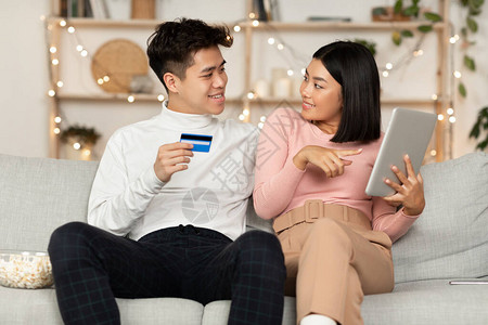 韩国夫妇使用数字平板电脑和信用卡在网上购物图片