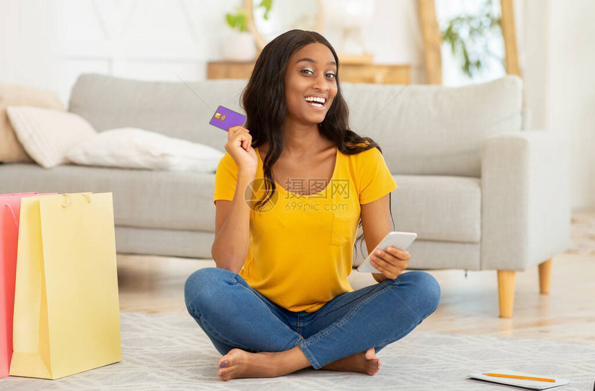 网络购物的概念有智能手机和信用卡的非裔美国女士在家里在线订购东西积极的黑人女在图片
