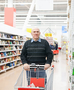 有手推车的老人在商店买杂货背景图片