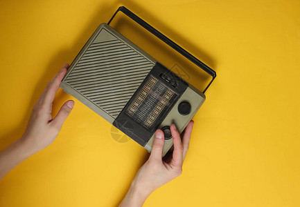 女手动曲调黄色背景的旧式收音机接收器RetroMassMedia图片