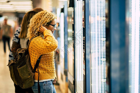 年轻女在机场自助食品和饮料机上的旅行理念图片