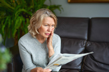 一家报纸在家中客厅的沙发上写着一个有关妇女读坏背景图片