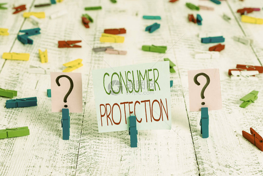 显示消费者保护的文字标志展示旨在保护消费者的法规的商业照片用纸夹放在木桌上的潦草和碎纸片图片