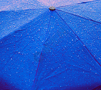 蓝色雨伞上的雨滴图片