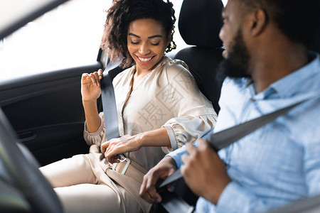 快乐的非洲情侣在车上系安全带测试汽车图片
