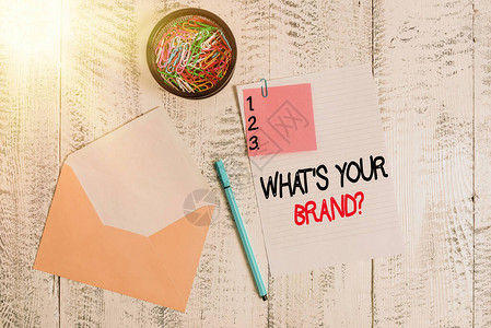 文字书写文本你的品牌问题是什么商业照片展示询问产品标志或您传达的内容信封纸便笺圆珠笔夹持背景图片