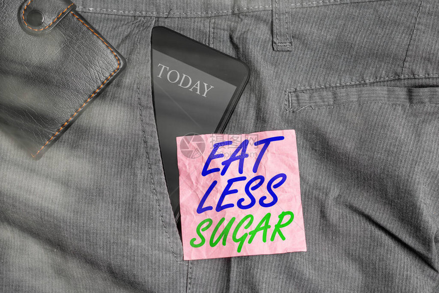 显示少吃糖的文字符号展示减少糖摄入量和吃健康饮食丰富食物的商业照片裤子前袋内的智能手机设备图片