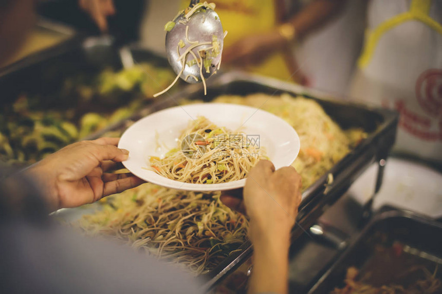 志愿者将美味食品交给无家可归饥饿和需要食物的人图片