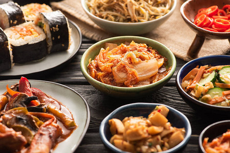 在木质表面的美味韩国菜盘附近背景图片