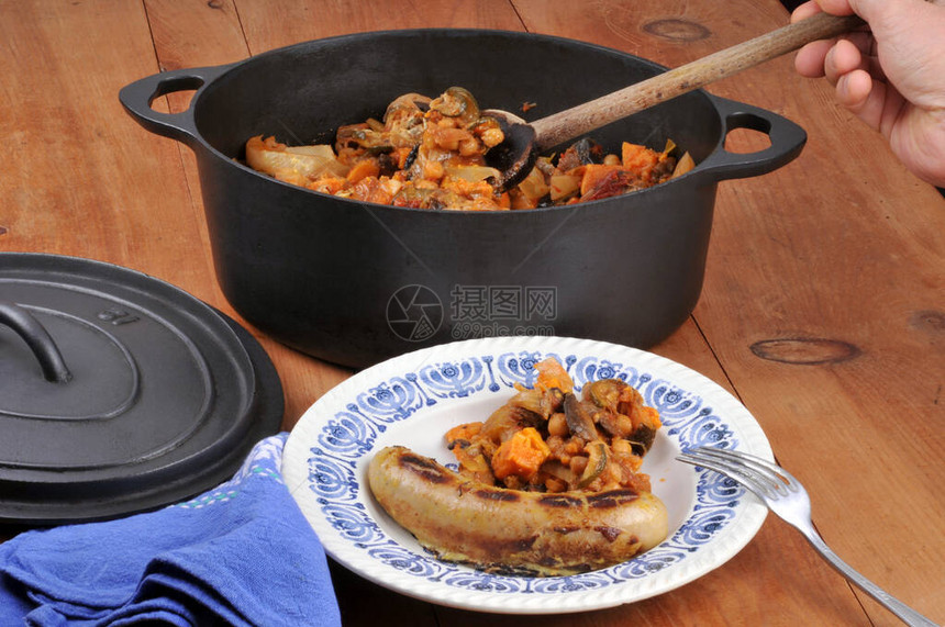 用铸铁砂锅烹制的蔬菜白香肠盘图片