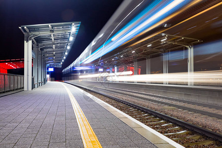 现代火车站在晚上鲜艳的色彩和快速模糊的运动快节奏的图片