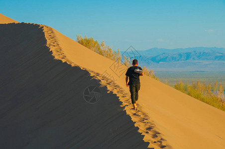 一个人爬上沙丘沙漠景观图片