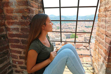 欧洲旅行妇女从意大利著名的中世纪旅游景点Asinelli塔顶看博图片