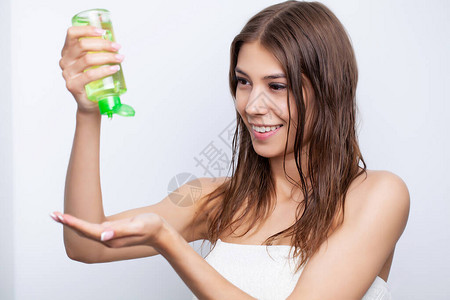 年轻妇女用天然油和调味剂来理发照图片