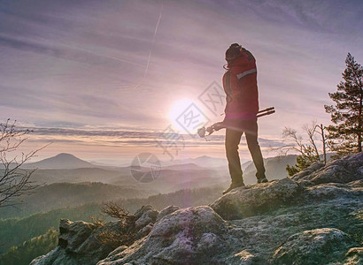 游客手持旅行三脚架摄影师登顶拍摄山顶日出图片