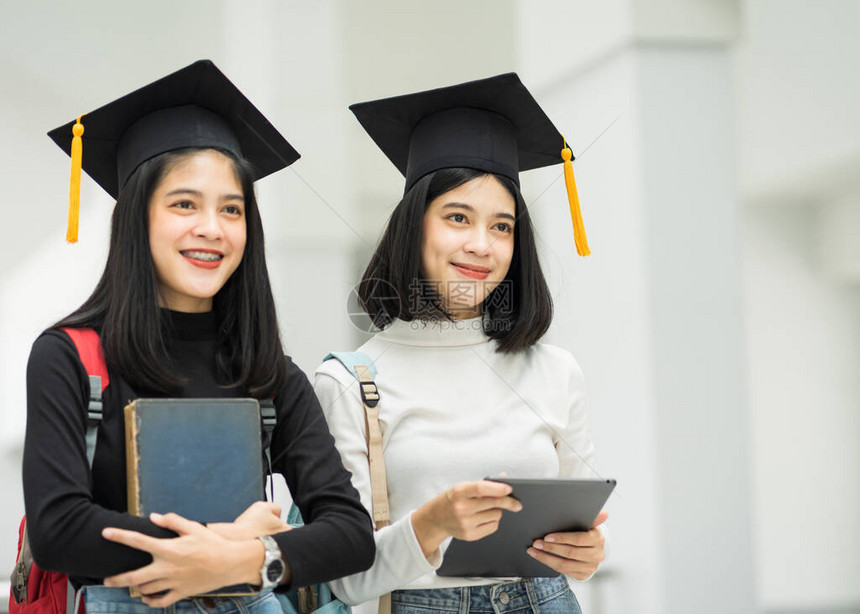 对持有背包书和戴毕业帽子的女青少年大学生的肖像代表了毕业概念教育版照片校对图片