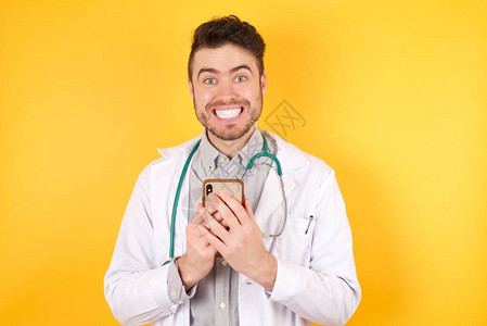 身着医疗制服手握电话的欧洲医生男子欢乐图片