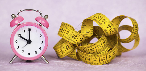体重损失饮食概念闹钟和磁带测图片