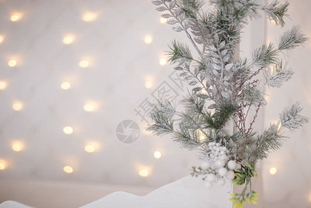 的银色闪亮球挂在冷杉树枝上灰色雪背景上的灯光和花环圣诞节和快乐的概念图片