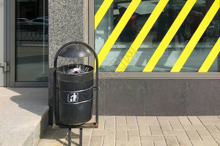 黑色垃圾桶站在街道上背景图片