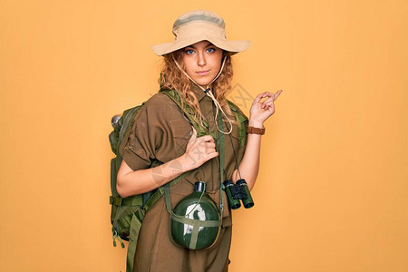 穿着背包和水食堂的蓝眼睛徒步走的金发年轻女探险家年轻女士图片