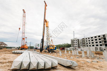 建筑桩和打桩机在建设多层住宅楼秋季背景图片