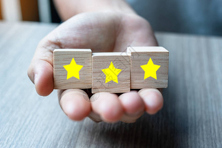 客户拿着带有三颗星符号的木块客户评论反馈评级排图片