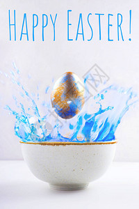 一个蓝色和的彩绘珍珠复活节彩蛋在一碗蓝色油漆中飞舞刻字复活节快图片