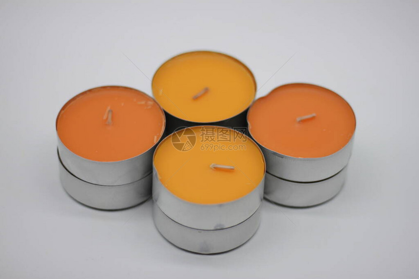 白色背景上的黄色和橙色香味蜡烛图片