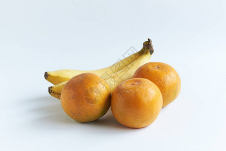 白色背景上的三个橙色水果和成熟的香蕉图片