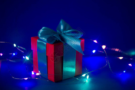 红色礼物盒蓝丝带在蓝色背景图片