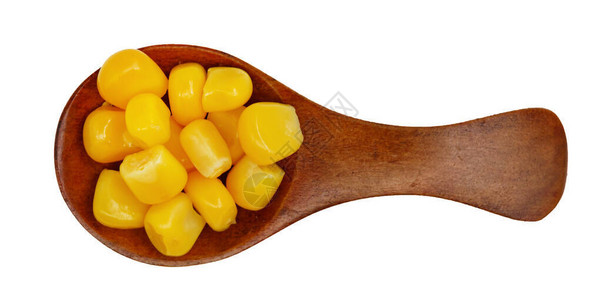 白本孤立的木勺子中的天然玉米种子以图片