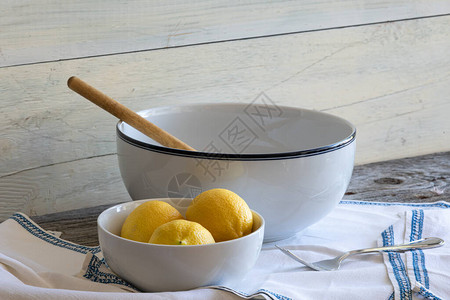 陶瓷碗三个柠檬和木勺图片