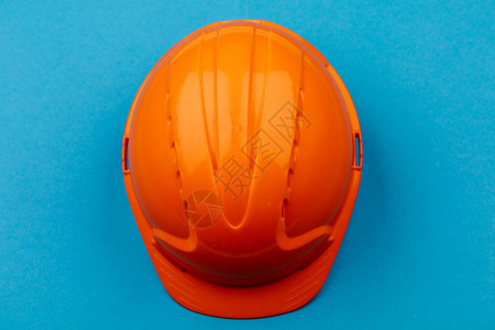 蓝色背景的橙色工程防护头盔图片
