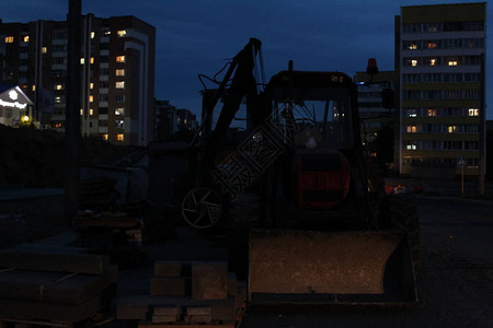 市区的拖拉机在城市建筑维修工作上晚上图片