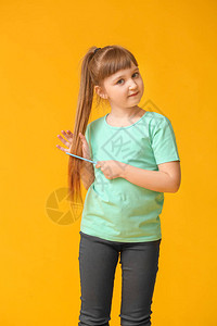 在彩色背景上梳理头发的小女孩图片