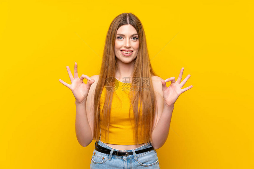 独身黄色背景的年轻女子用手指标图片